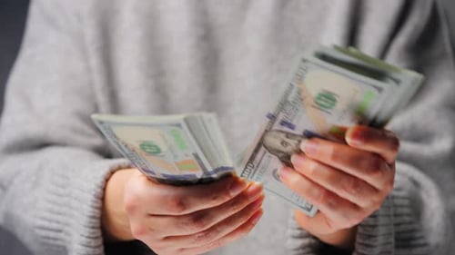 Counting money, stacks of hundred dollar bills