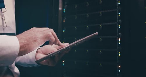Man in data center typing on tablet, inspection or network maintenance with engineer in storage
