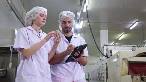 Deux inspecteurs examinent les conserves et le contrôle de la qualité en usine.