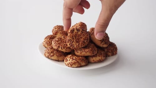 Sesame Cookies on Plate Being Picked Up