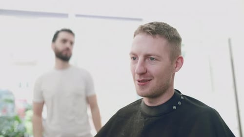 Man Getting Haircut by Barber in Bright Salon