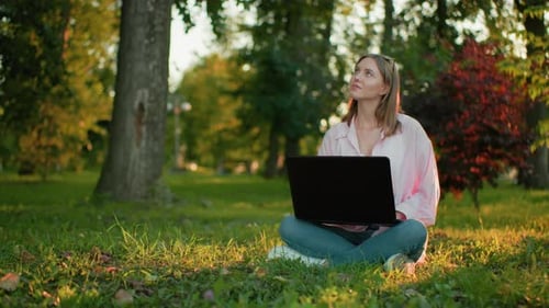 Woman Working on Laptop in a Park