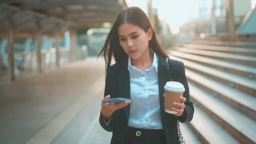 Woman Walks and Talks on Phone with Coffee