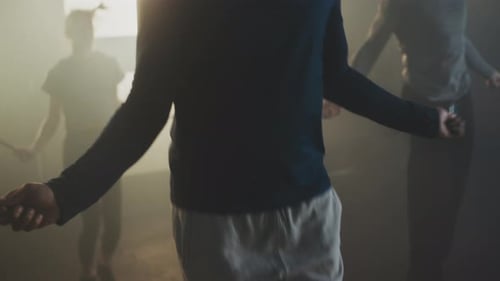 Men Skipping Rope in Brightly Lit, Foggy Gym