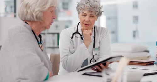 Doctor Explains Information to Patient Using Tablet