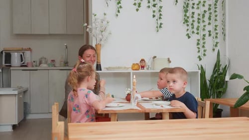 Woman and Children Eating at Table with Candle