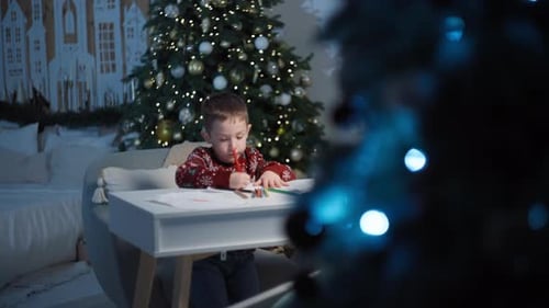 Boy Drawing Christmas Pictures at Home