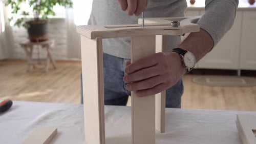 Adult Assembling Wooden Furniture at Home