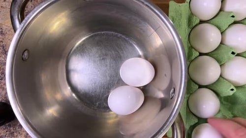 Rohe Hühnereier zum weiteren Garen in eine Metallpfanne geben. Ansicht von oben.
