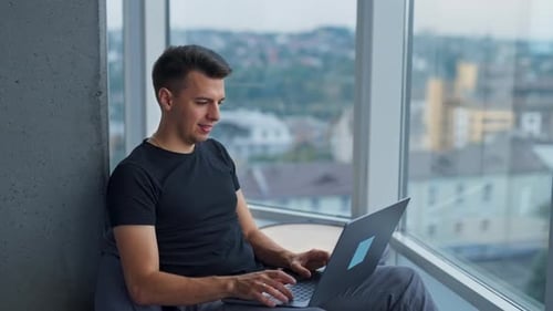 Junger kreativer, gutaussehender Freelancer, der am Computer arbeitet.