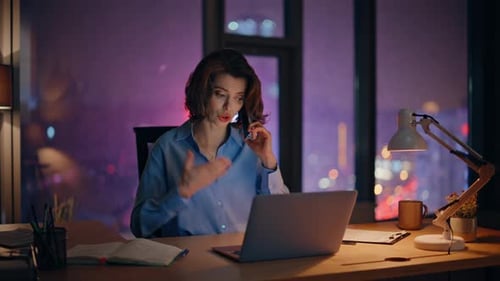 Troubled Entrepreneur Calling Cellphone Looking Laptop at Night Office Closeup