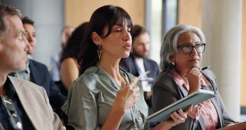 Business professionals listen during conference presentation indoors