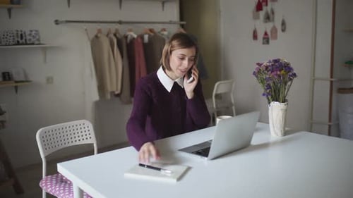Woman talking on phone and taking notes