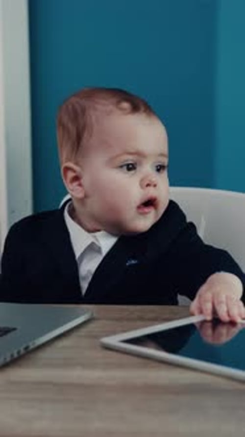 Infant in Suit with Laptop and Tablet