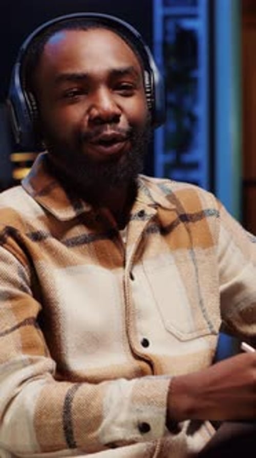 Vertical Video Man Recording Interview with Professional Camera in Studio Reviewing Notes to Ask