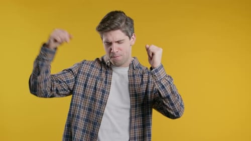 Happy Man Dancing in Celebration on Yellow Background