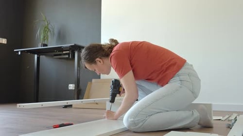 Woman Assembling Furniture at Home Using Power Drill