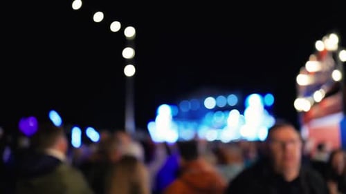 A Vibrant Outdoor Night Scene with a Large Crowd Illuminated By Colorful Lights at a Celebratory
