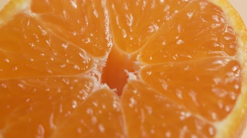El primer plano extremo de la mitad de una mandarina gira, centrándose en el centro y las jugosas membranas.