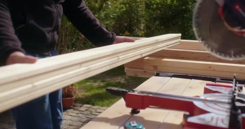 Adult Using Power Saw to Cut Wood