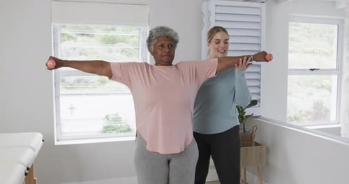Senior Woman Lifting Weights with Support Indoors