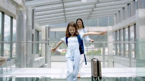 Mother with Daughter Going on Holiday, Wearing Face Masks at the Airport