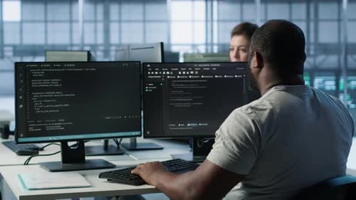 Developer Typing Code on PC to Mend Data Center Racks