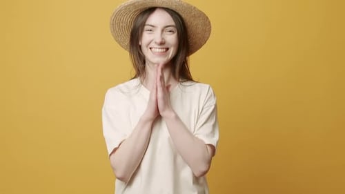 Smiling Woman Clapping Hands with Straw Hat On