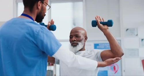 Senior Man Working with Trainer at Rehabilitation Center