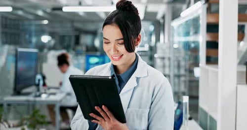 Smiling Woman Working with Tablet in Modern Laboratory