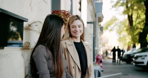Young Women with Coffee Chatting on Street