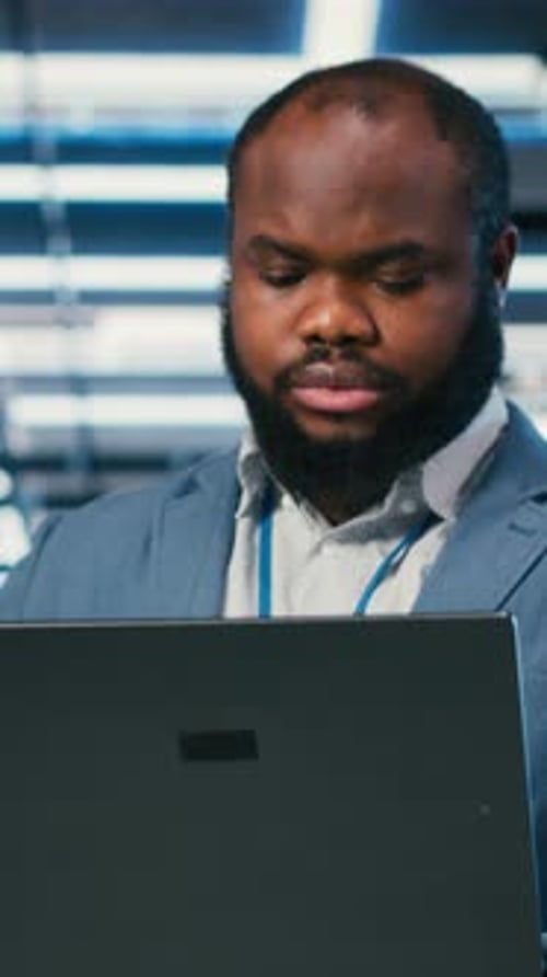 Vertical Video Software Developer in Server Farm Using Laptop Doing Network Management