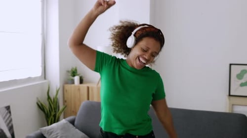 Woman Dancing Energetically with Headphones at Home