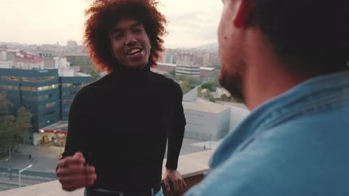 Zwei Jungs, Freunde, unterhalten sich stehend auf der Terrasse.