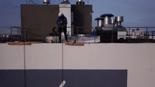 Industriekletterer arbeitet in der Höhe mit Seilen. Service im Hochhaus.