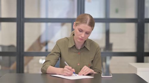 Mature Adult Woman Writing a Letter in Office