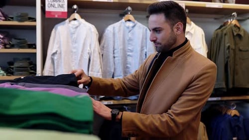 Bonito empresário moderno comprando roupas novas na loja