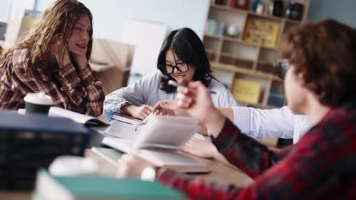 Vielfältige Gruppe von Studierenden, die zusammen in einer Bibliothek studieren