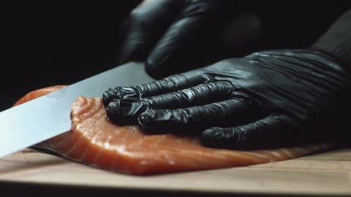 Hands Cut Fresh Salmon with Sharp Knife