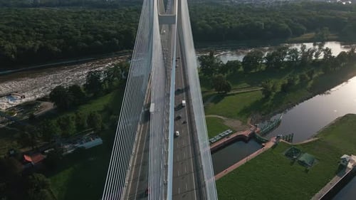 Aerial view of cable-stayed bridge over river with traffic at sunset
