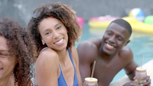 Biracial woman and African American man enjoy a pool party