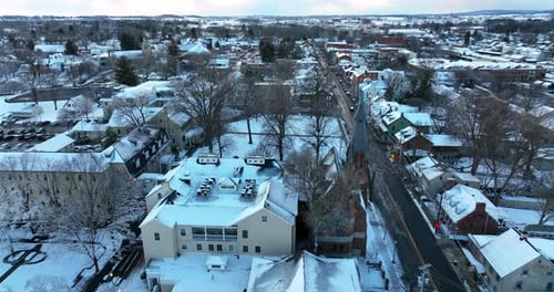 Lititz Pennsylvania in winter snow. Aerial truck shot of Linden Hall and church steeple. Small Town