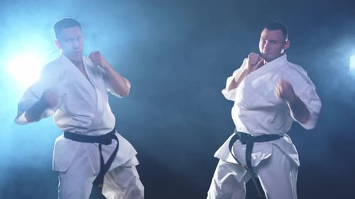 Kampfsportmeister auf dunklem Hintergrund Starke Mannkämpfer im weißen Kimono für Karate-Kampfkünste