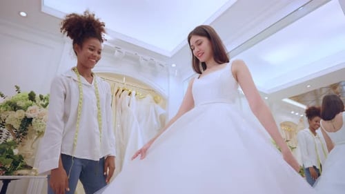 Beautiful bride discussing details with the wedding planner in studio.