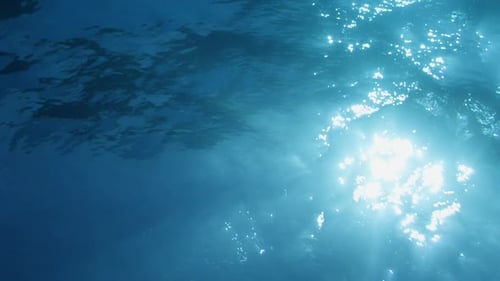Light playing through the ocean surface seen from below. Underwater background VFX element.