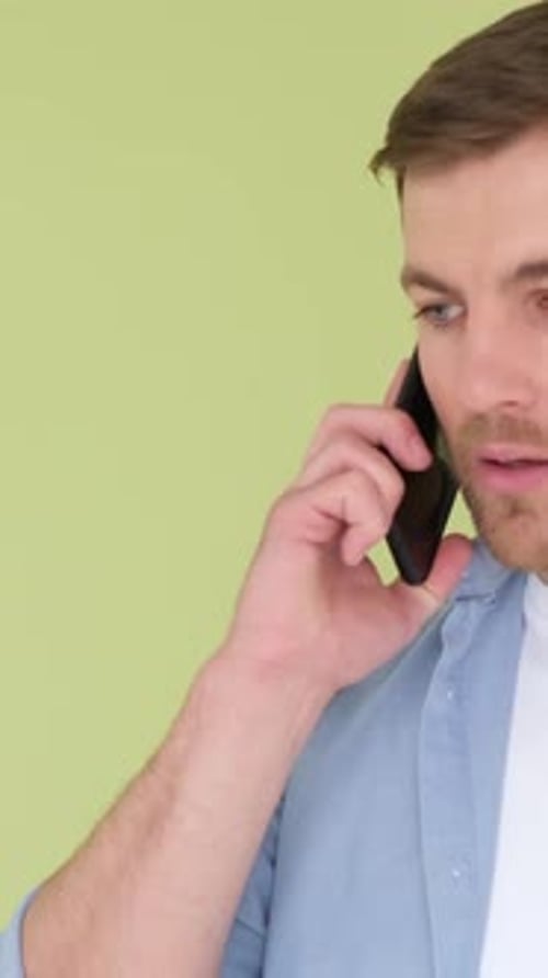 Aggressive Man Talking on Smartphone and Shouting Displeased Isolated on Background in Studio