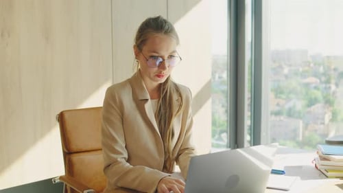 In a Modern Office a Businesswoman Entrepreneur is Focused on Tasks Typing on a Laptop Under Natural