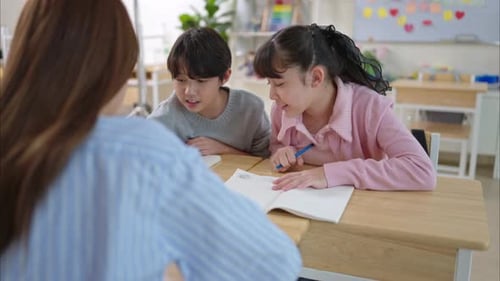Children Work on Drawings in Classroom with Teacher