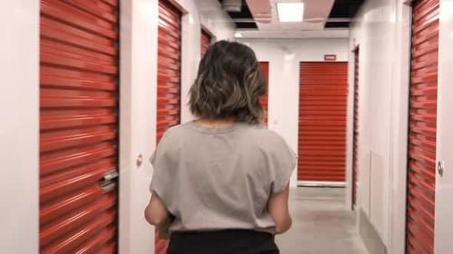 Femme portant une boîte en carton dans le couloir de l'installation de stockage