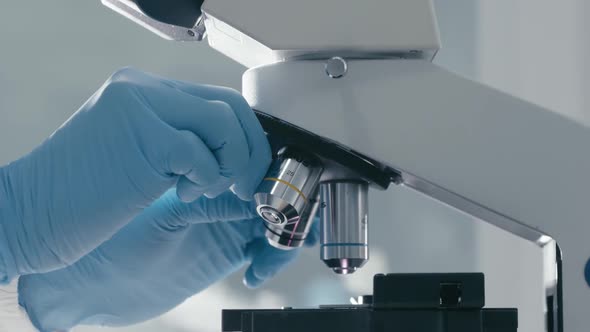 Scientists rotate microscope lenses to adjust the object to be observed ...